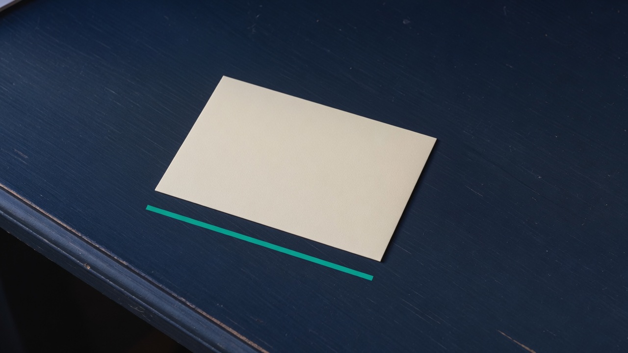 Cream stationery and a teal accent on a dark navy desk