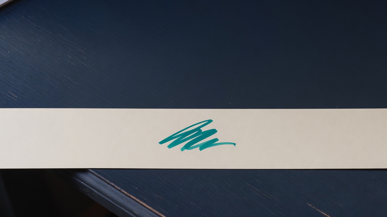 Cream stationery and a teal accent on a dark navy desk