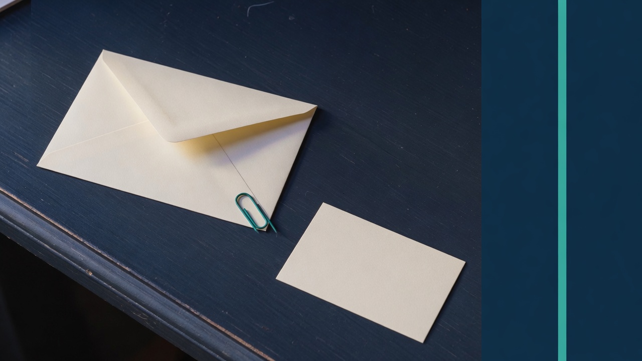 Cream stationery and a teal accent on a dark navy desk
