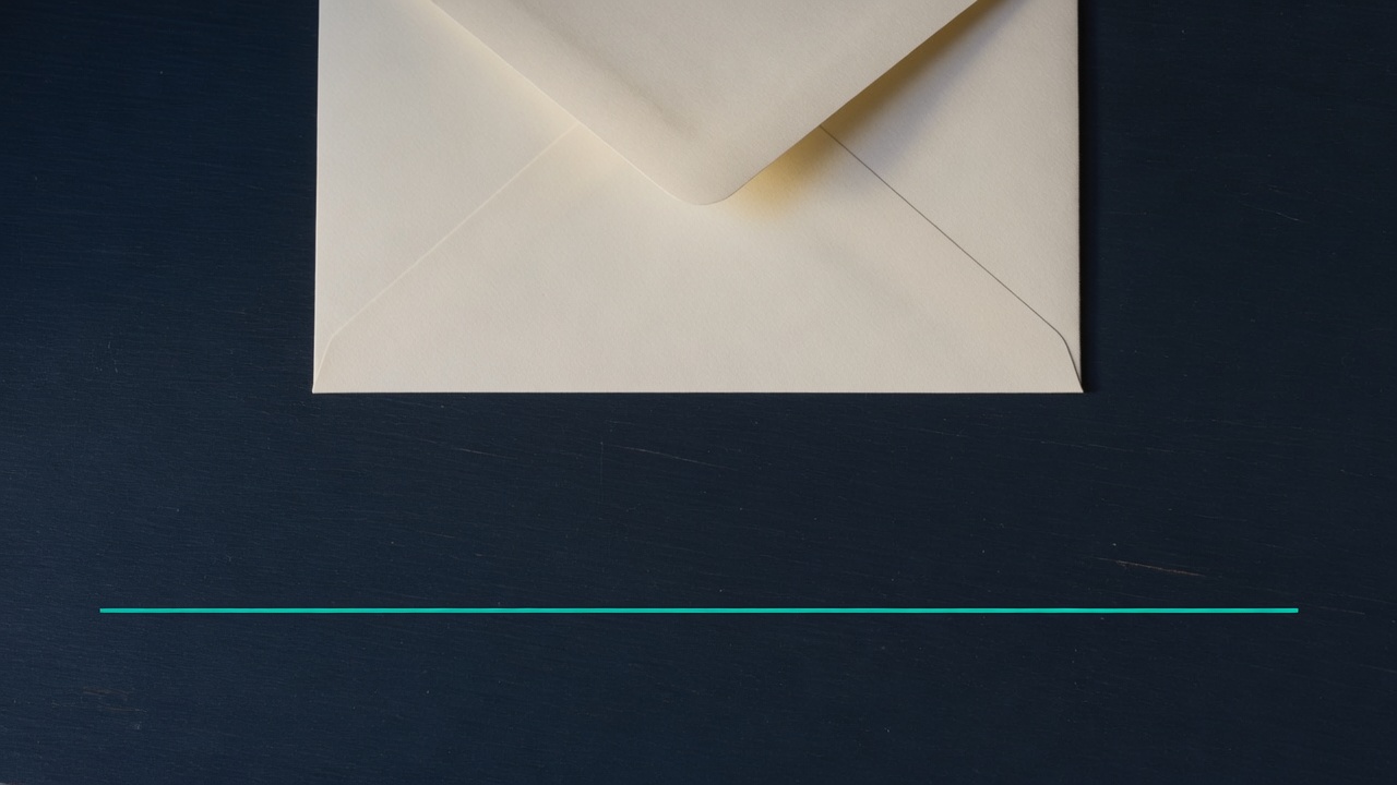 Cream stationery and a teal accent on a dark navy desk