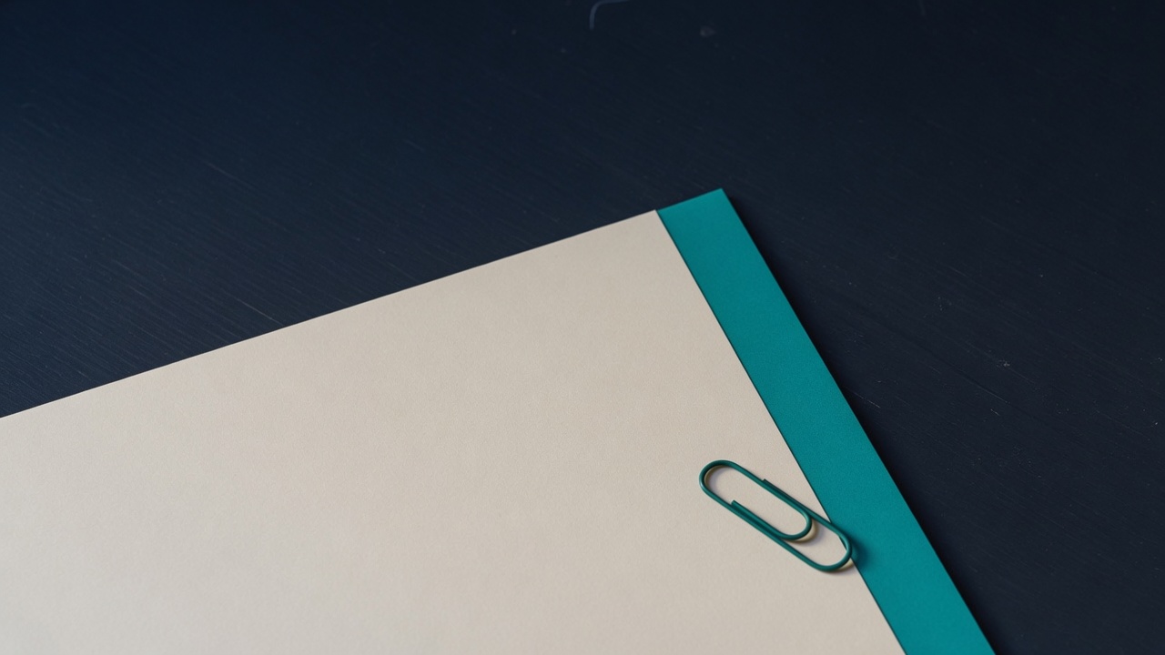 Cream stationery and a teal accent on a dark navy desk