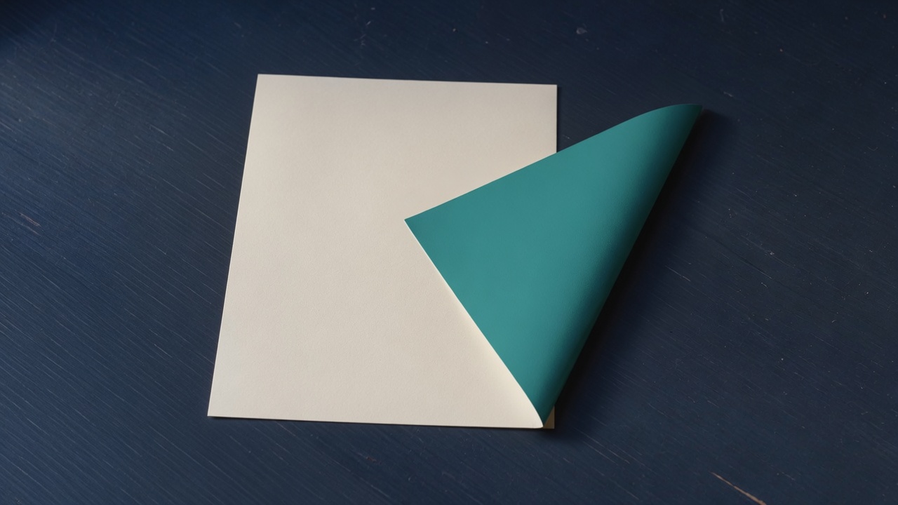 Cream stationery and a teal accent on a dark navy desk