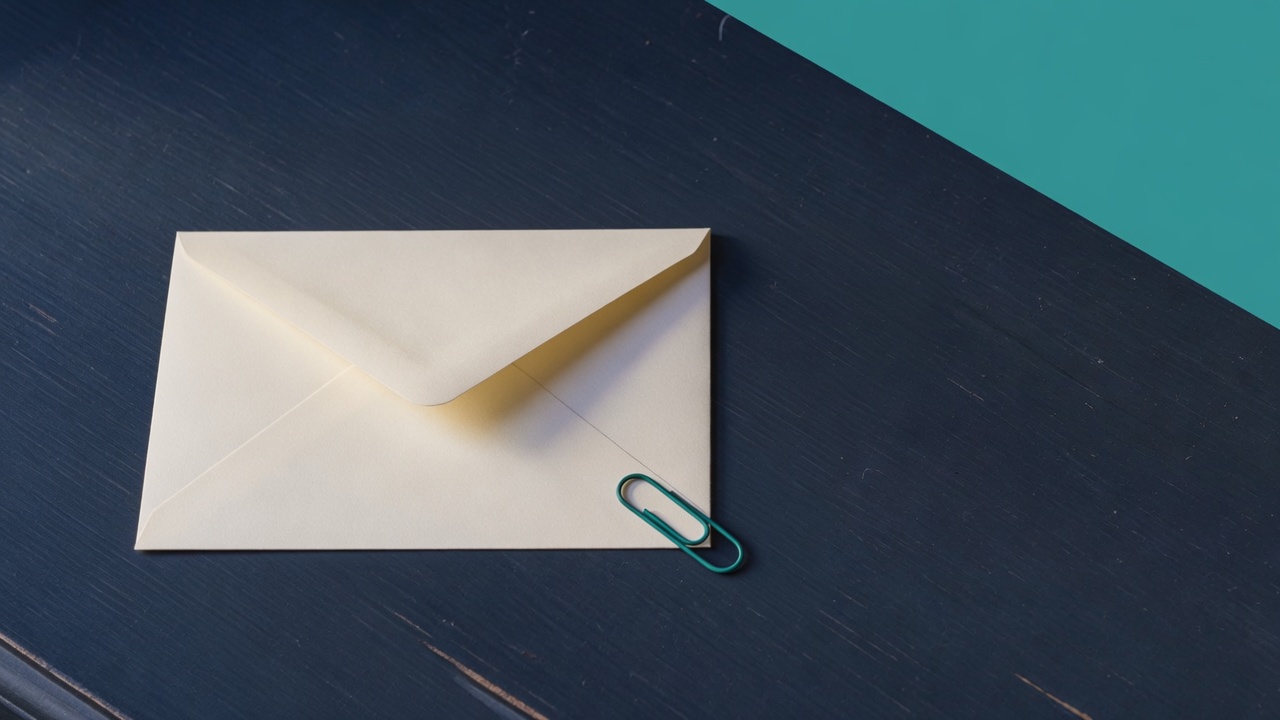 Cream stationery and a teal accent on a dark navy desk