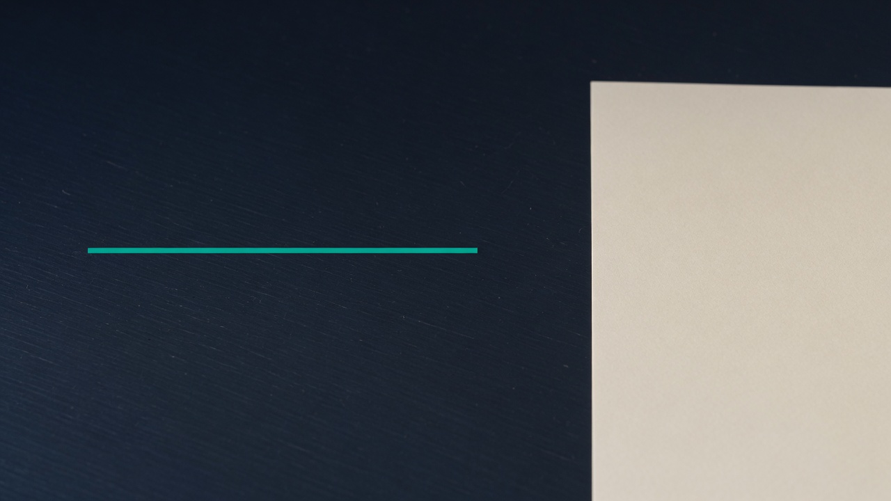 Cream stationery and a teal accent on a dark navy desk