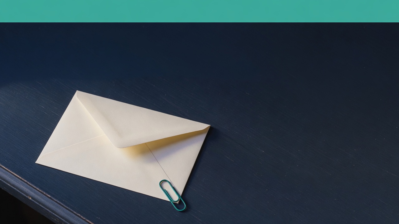 Cream stationery and a teal accent on a dark navy desk