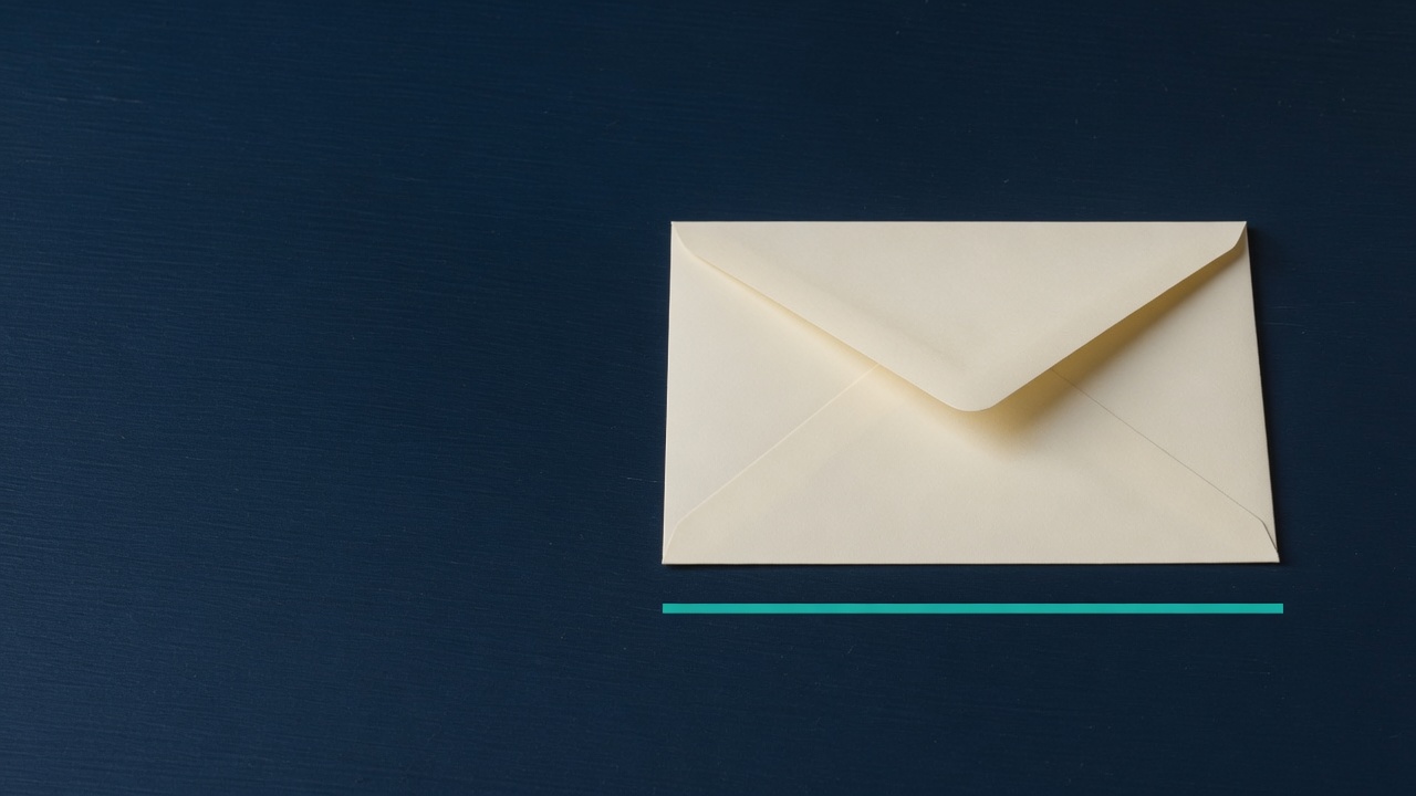 Cream stationery and a teal accent on a dark navy desk