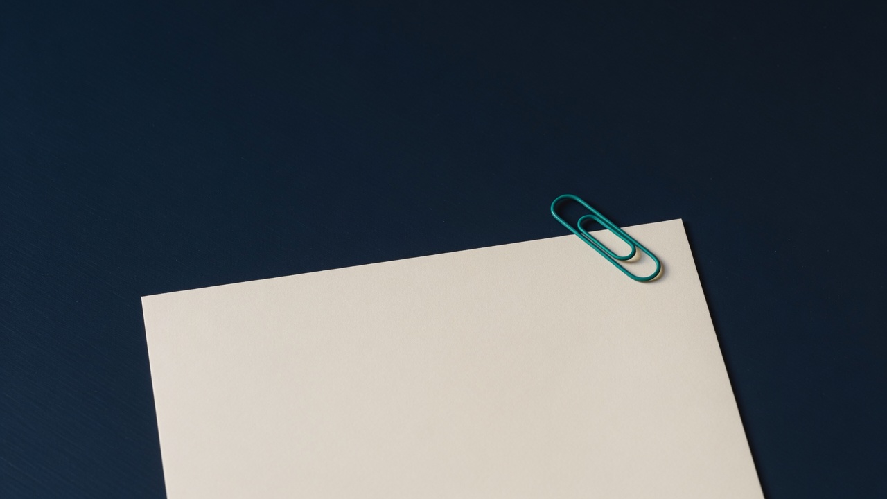 Cream stationery and a teal accent on a dark navy desk