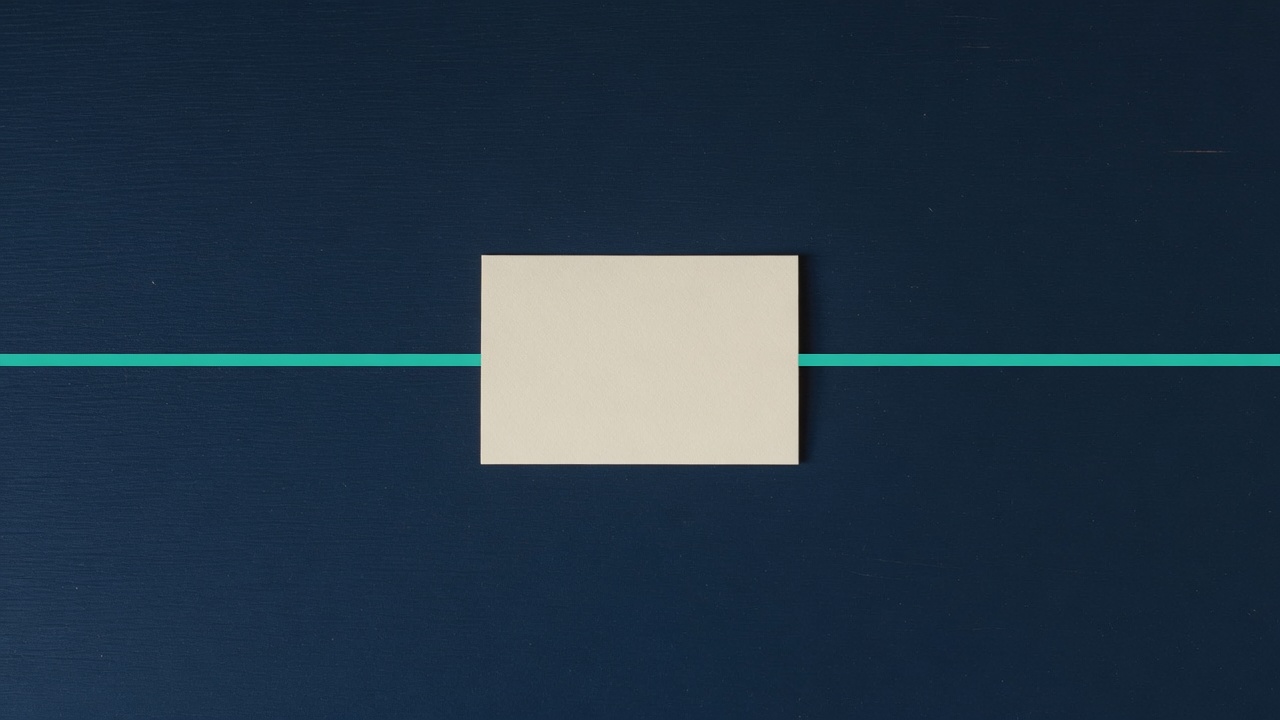 Cream stationery and a teal accent on a dark navy desk