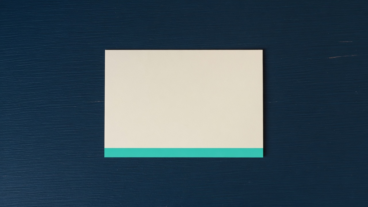 Cream stationery and a teal accent on a dark navy desk
