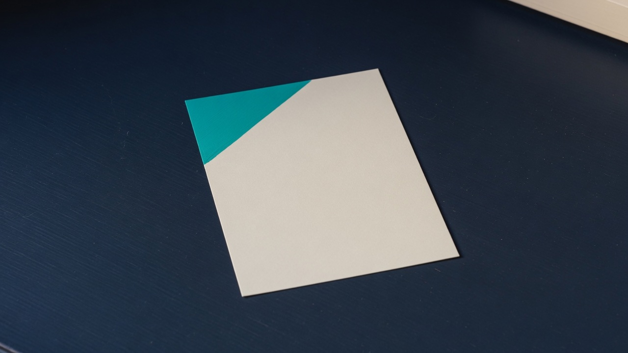 Cream stationery and a teal accent on a dark navy desk