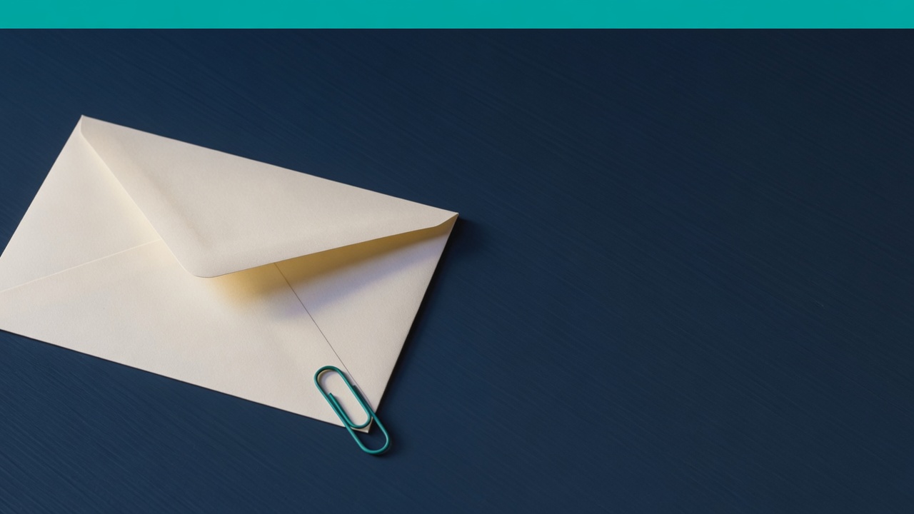 Cream stationery and a teal accent on a dark navy desk