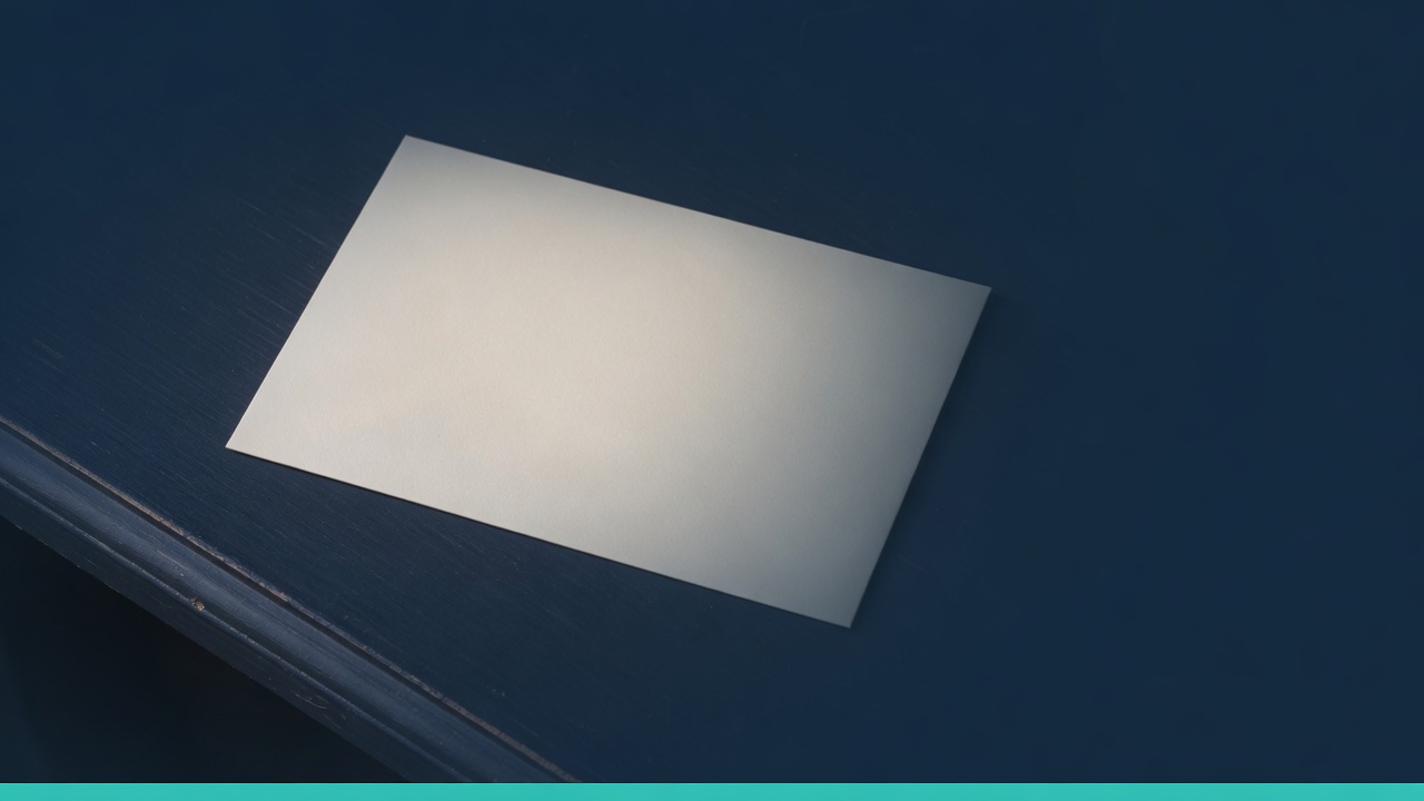 Cream stationery and a teal accent on a dark navy desk