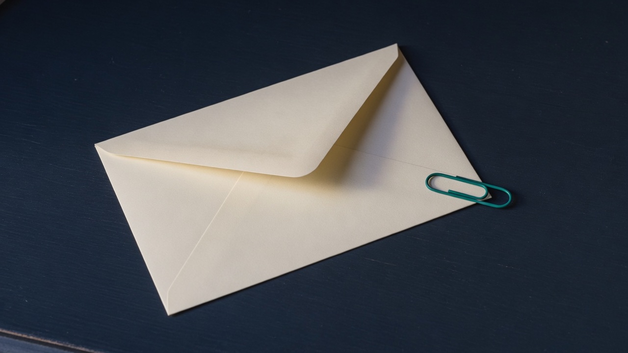 Cream stationery and a teal accent on a dark navy desk