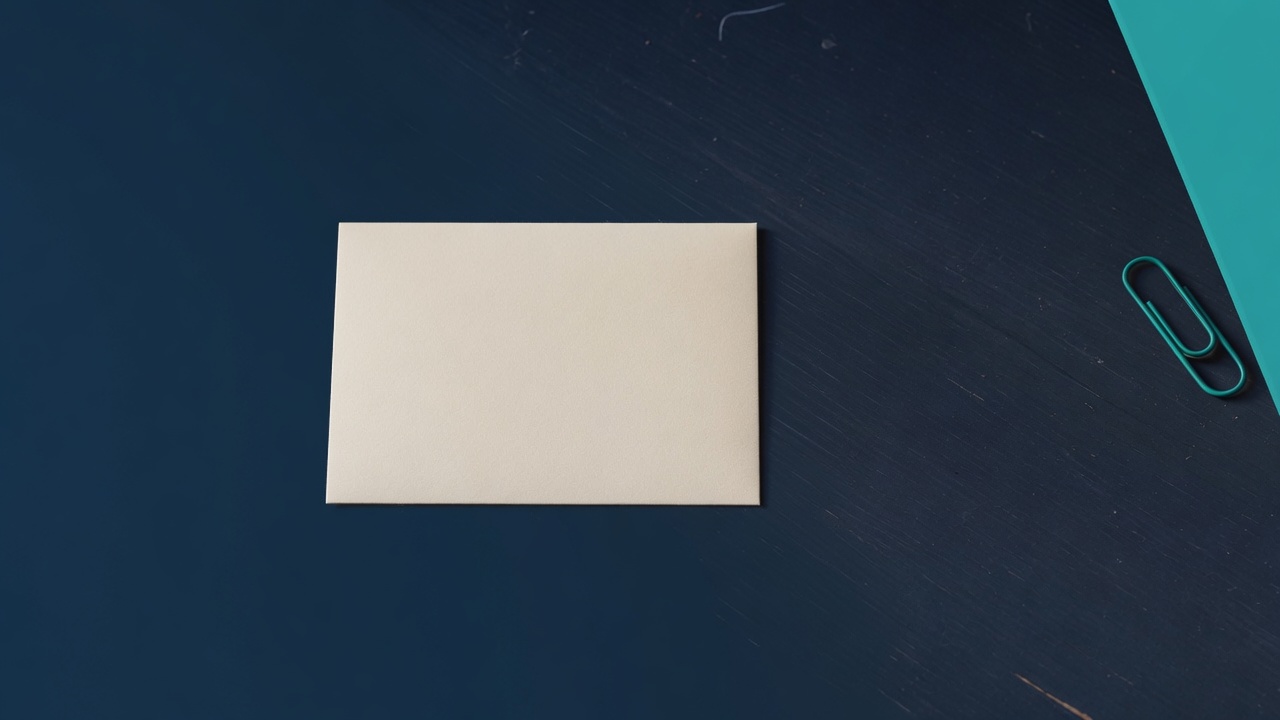 Cream stationery and a teal accent on a dark navy desk