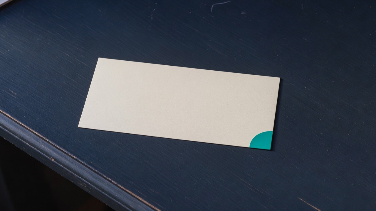 Cream stationery and a teal accent on a dark navy desk