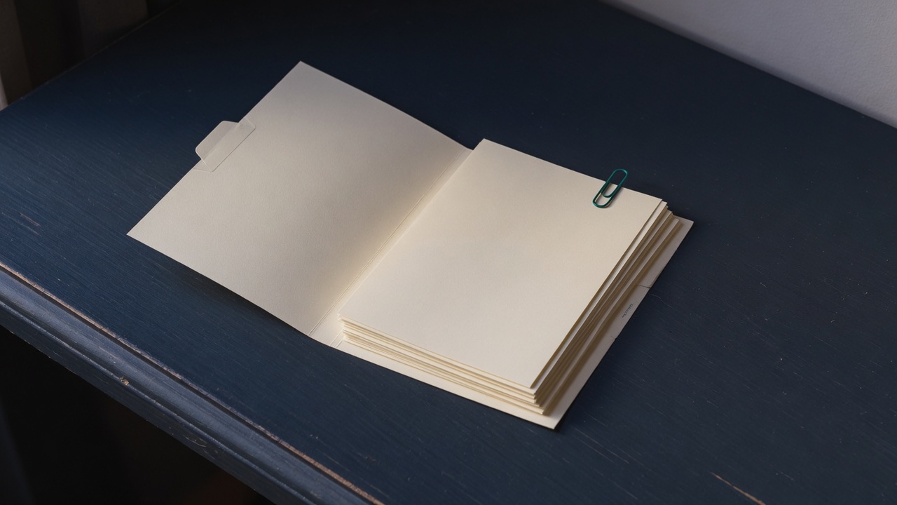 Cream stationery and a teal accent on a dark navy desk