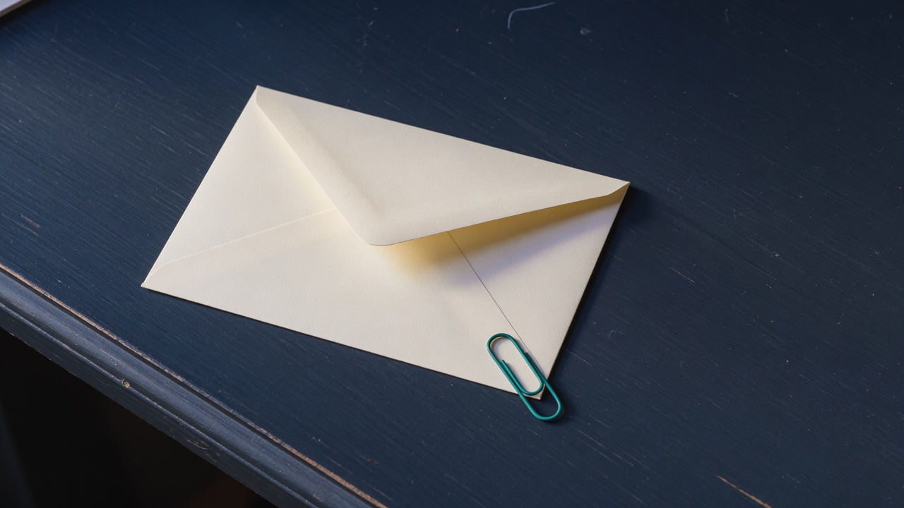 Cream stationery and a teal accent on a dark navy desk