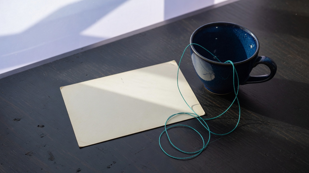 Cream stationery and a teal accent on a dark navy desk