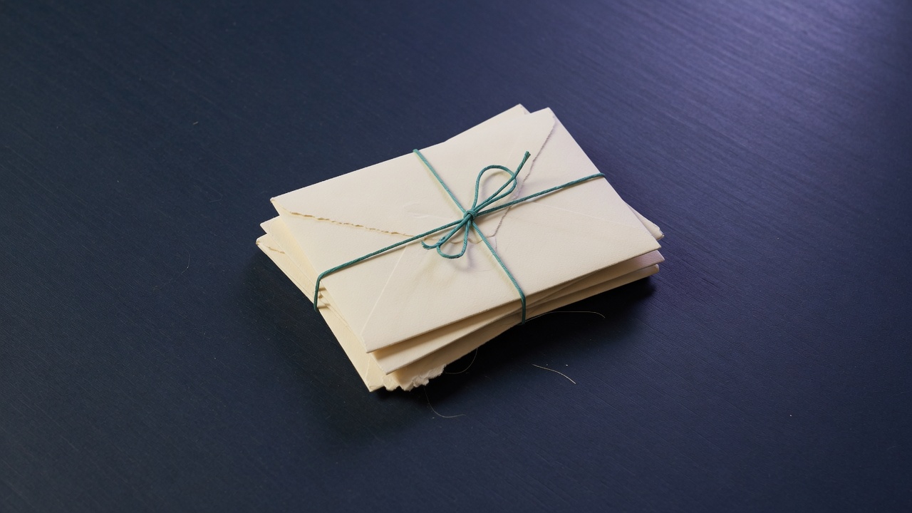 Cream stationery and a teal accent on a dark navy desk