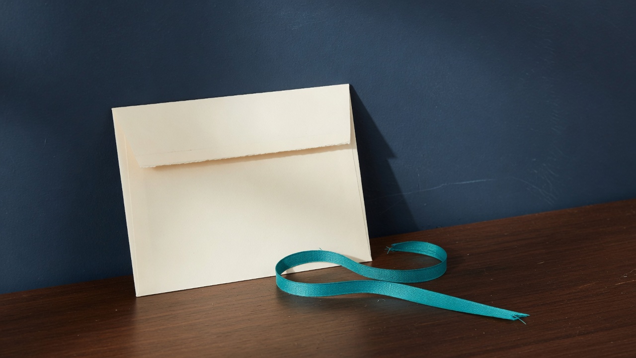 Cream stationery and a teal accent on a dark navy desk