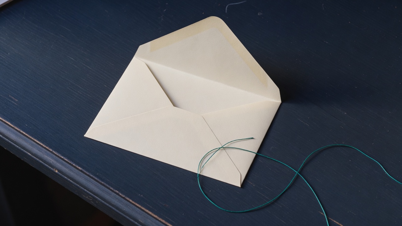 Cream stationery and a teal accent on a dark navy desk