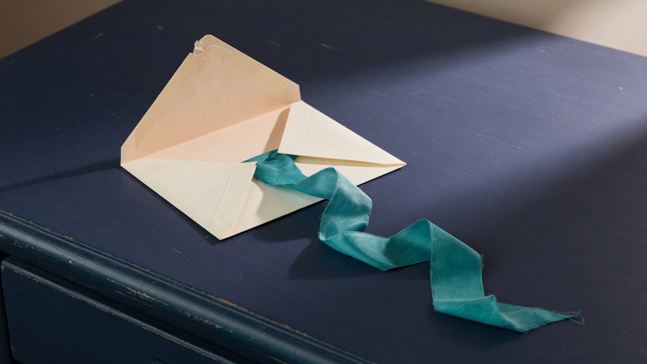 Cream stationery and a teal accent on a dark navy desk