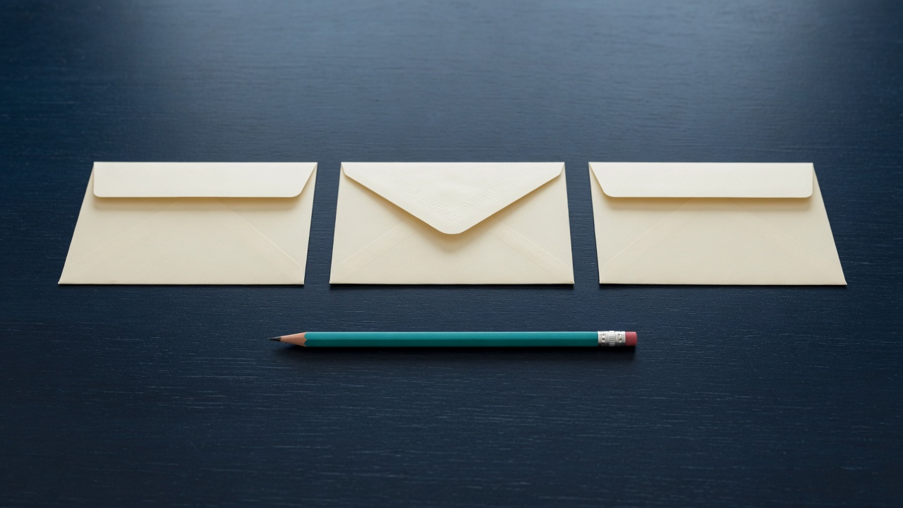 Cream stationery and a teal accent on a dark navy desk